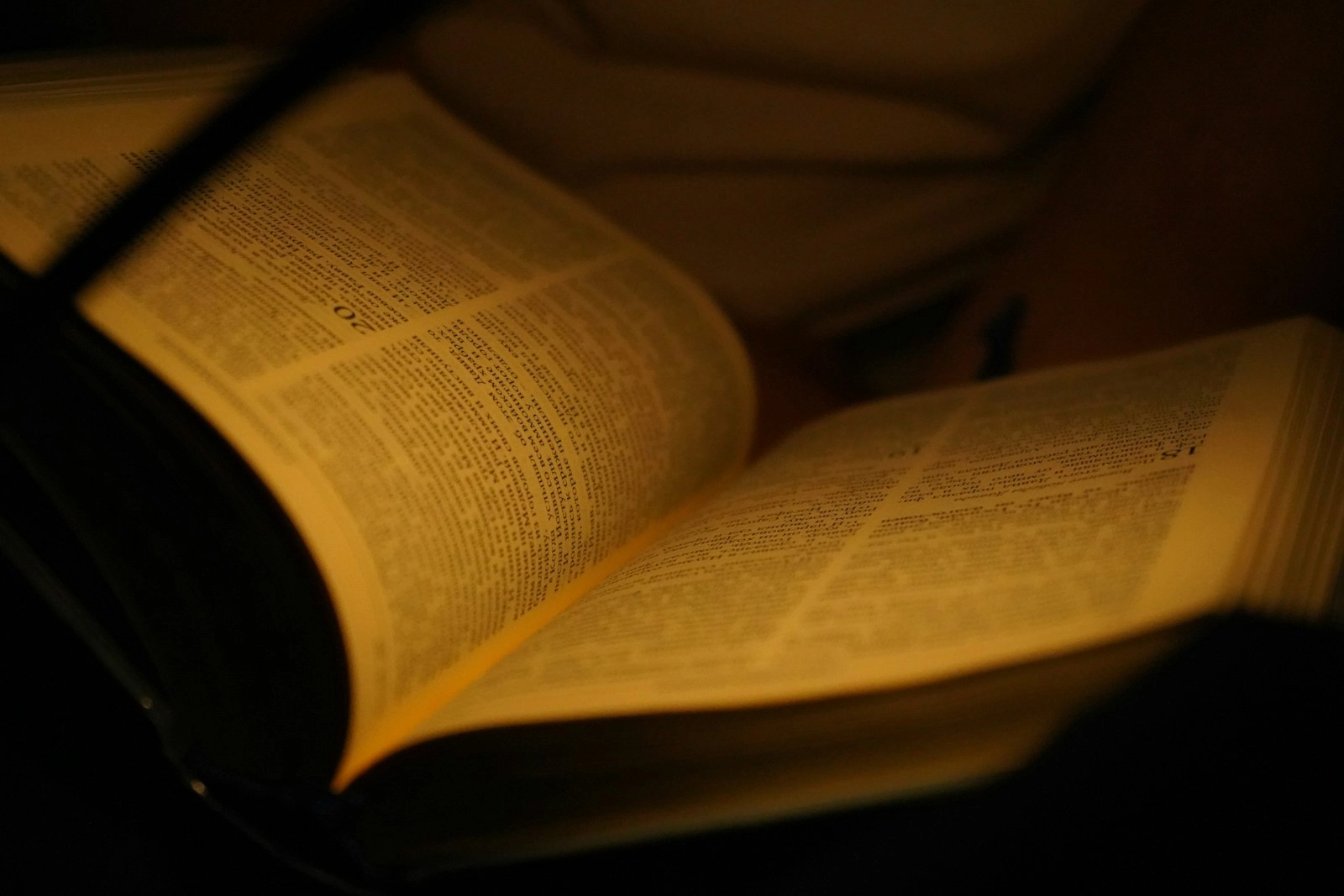 An open book illuminated by warm light.
