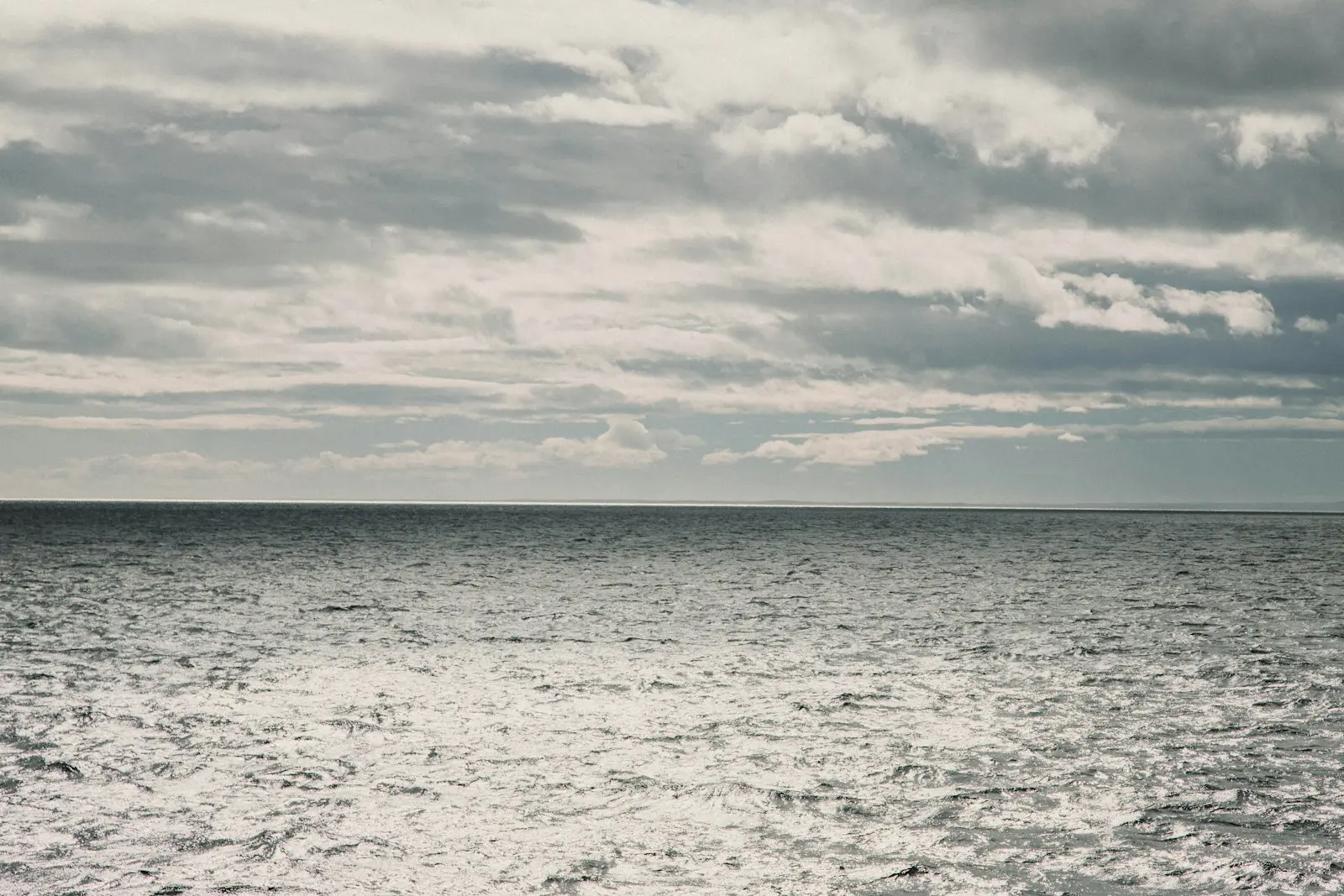 A large body of water sitting under a cloudy sky
