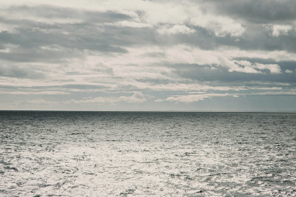 A large body of water sitting under a cloudy sky