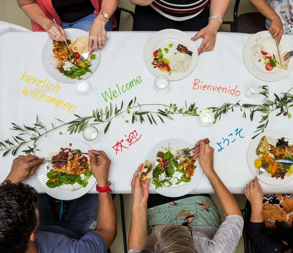 A group of people sitting around a table with plates of food